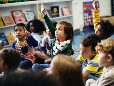 niños y niñas de diferentes culturas participando activamente en clase, representando la diversidad cultural en el aula.