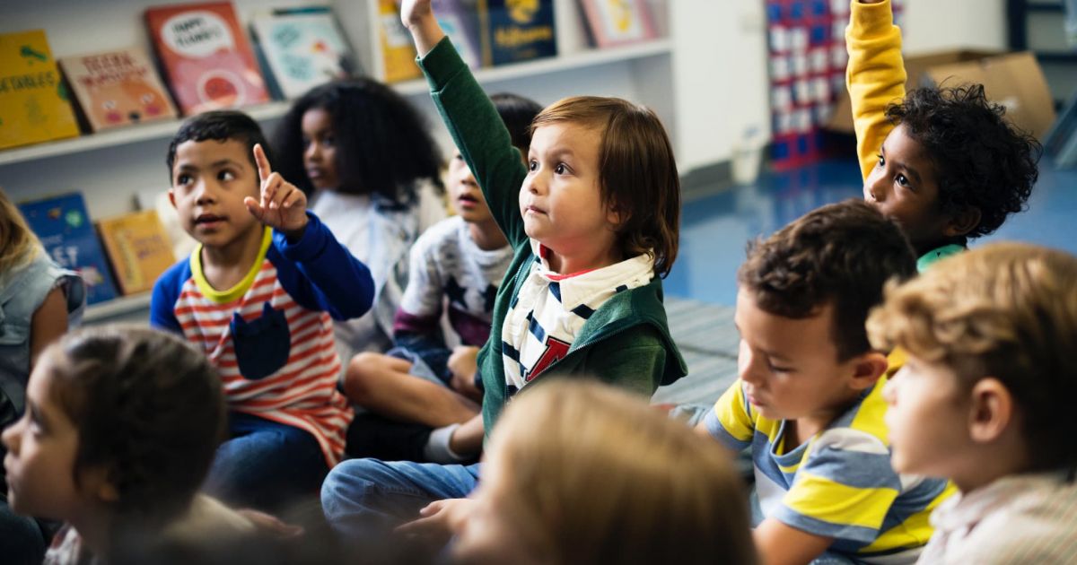 niños y niñas de diferentes culturas participando activamente en clase, representando la diversidad cultural en el aula.